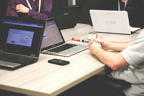 Team having meeting around the table with laptops open