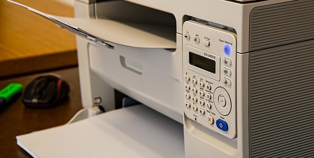 Office printer filled with paper ready for printing